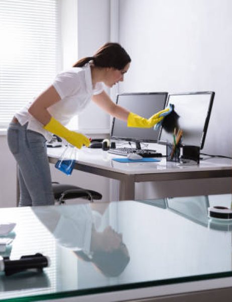 young woman cleaning computer with rag in office young woman cleaning computer with rag in office